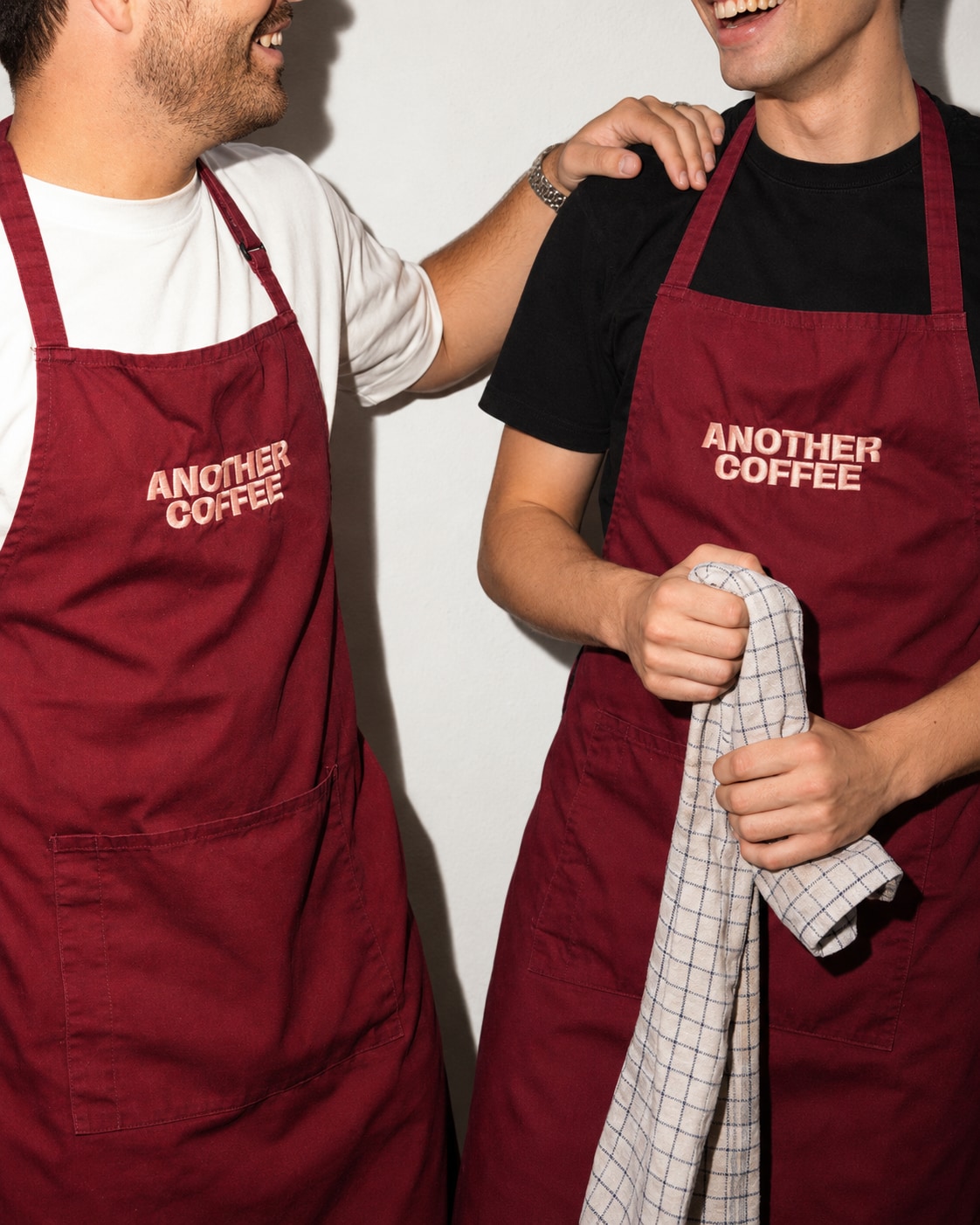 Two colleagues in burgundy Another Coffee aprons